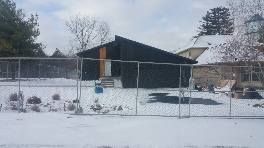 house with black siding in snow